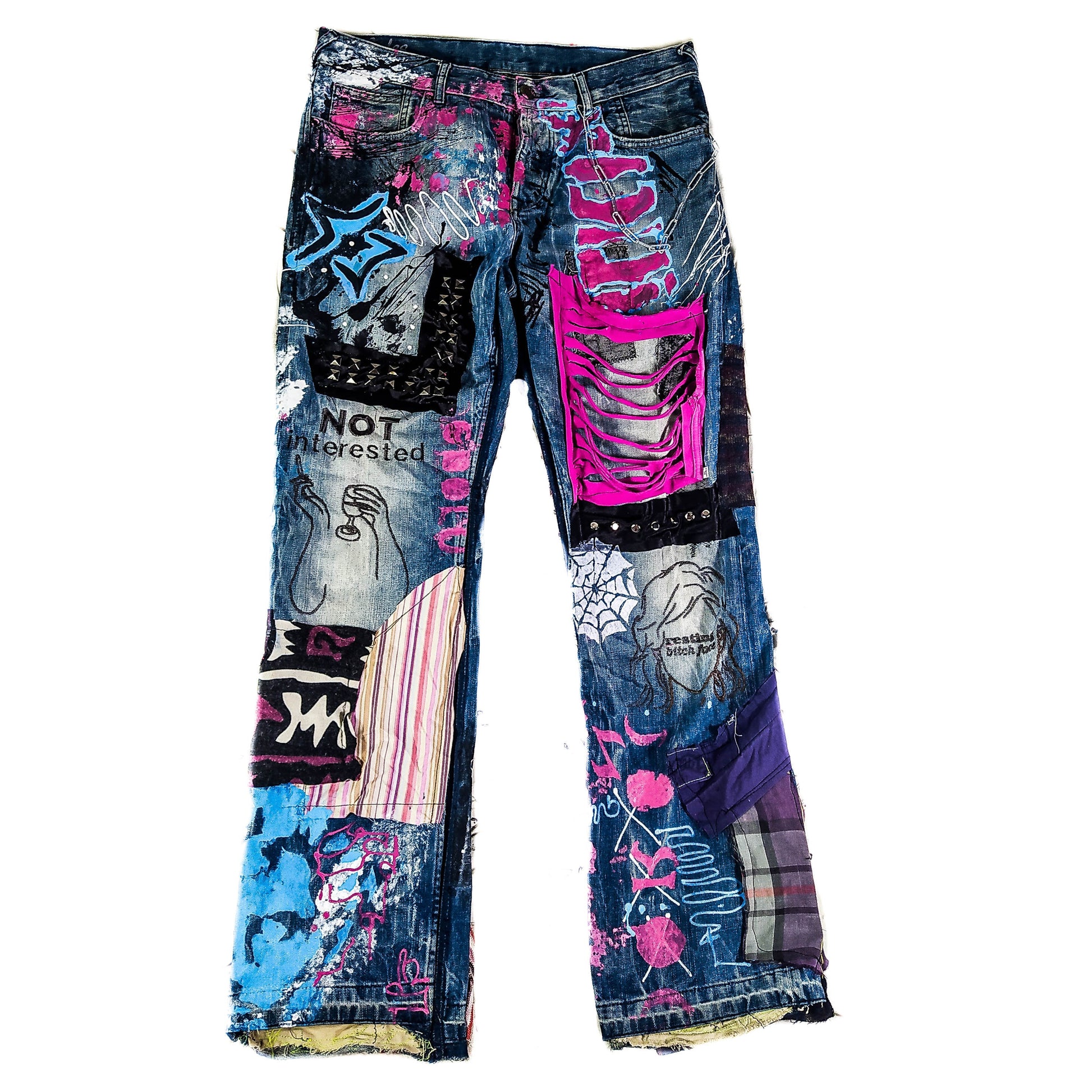 Model wearing the blue pants with abstract one line embroideries representing women saying I&#39;m not interested on one leg and Resting bitch face on the other. Colorful patchwork with add ons such as studs, zippers and elastic laces hanging down.