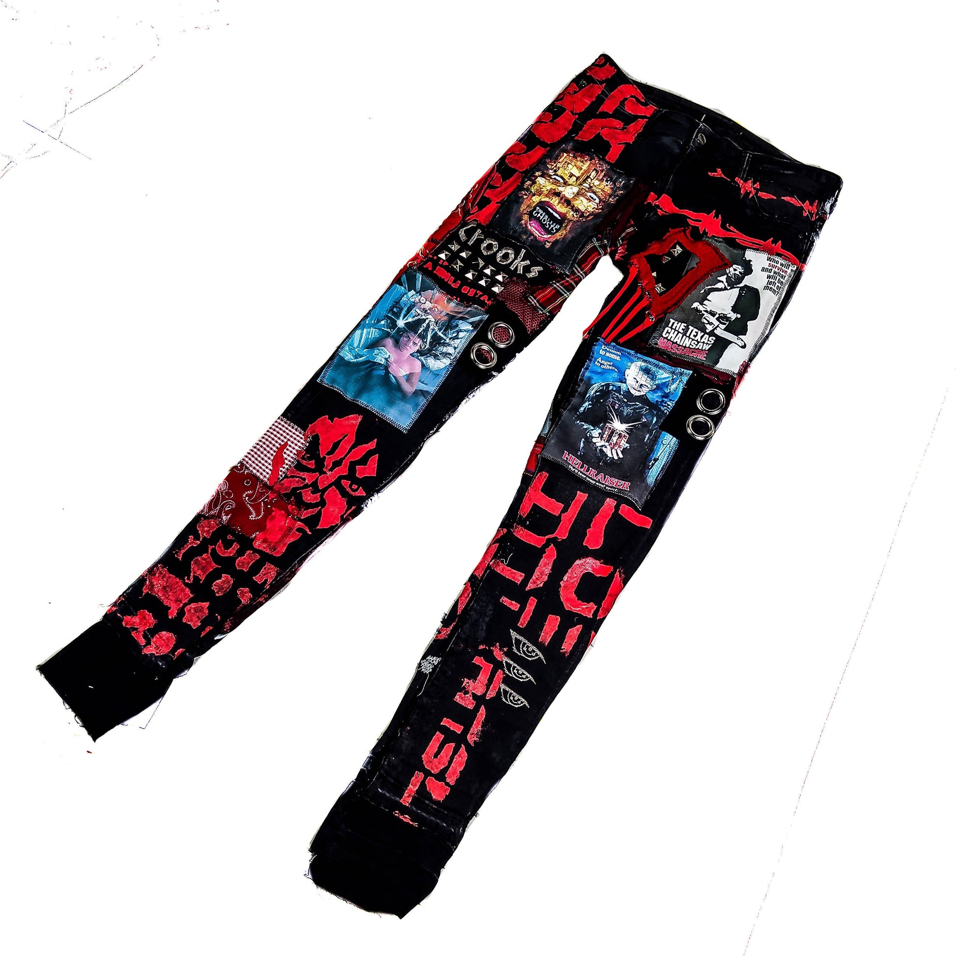 Flat laid skinny custom made black pair with prints containing various horror movies, red and black patchwork, abstract painting, studs, red laces hanging down, chain and eyelets.