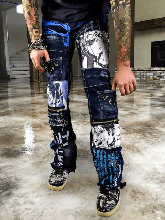 Model showing a black pair of pants with nana anime prints, pockets sewn on the pants, zippers, abstract patchwork and painting, color scheme is black and blue.