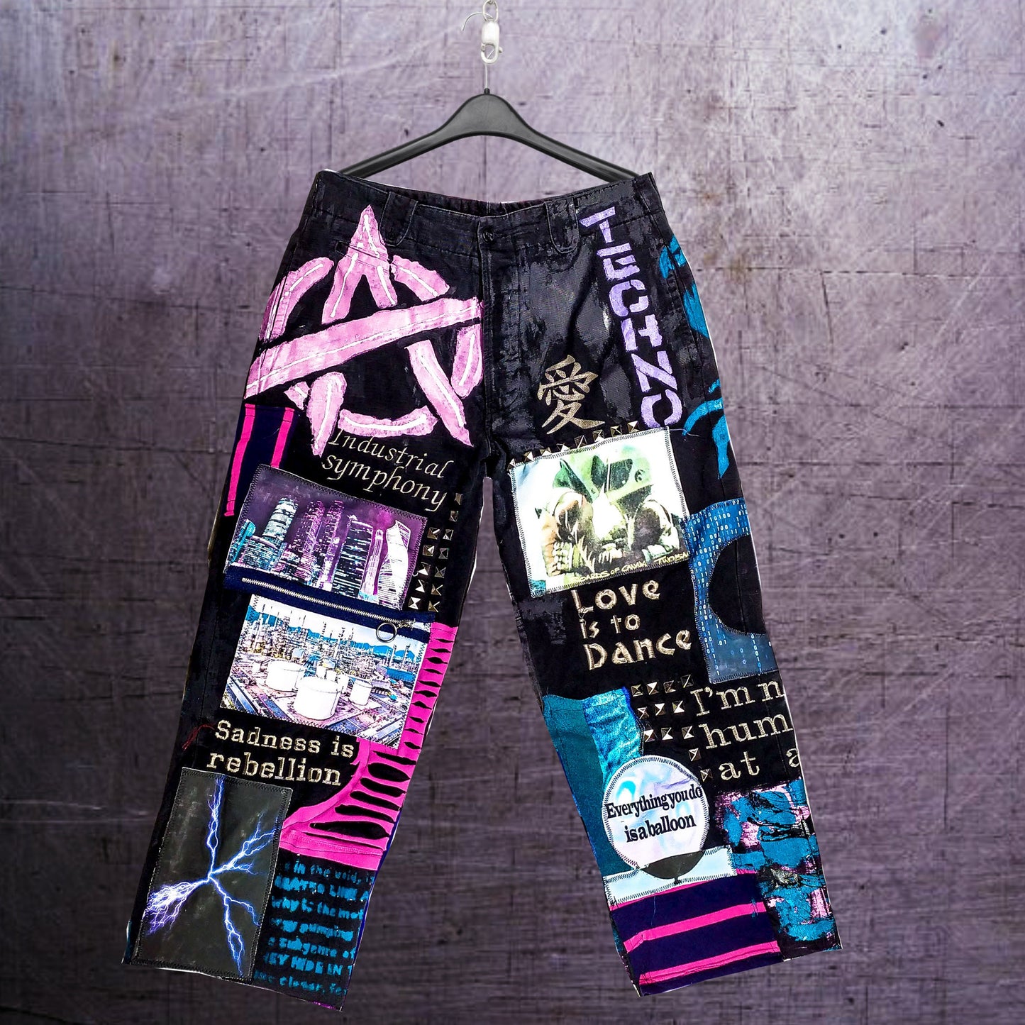 On the pair there are embroidered phrases, such as Love is to dance, Industrial symphony, Sadness is rebellion. There are also prints with chemical plants and cyberpunk themed ones. Zippers, studs, and abstract painting included.