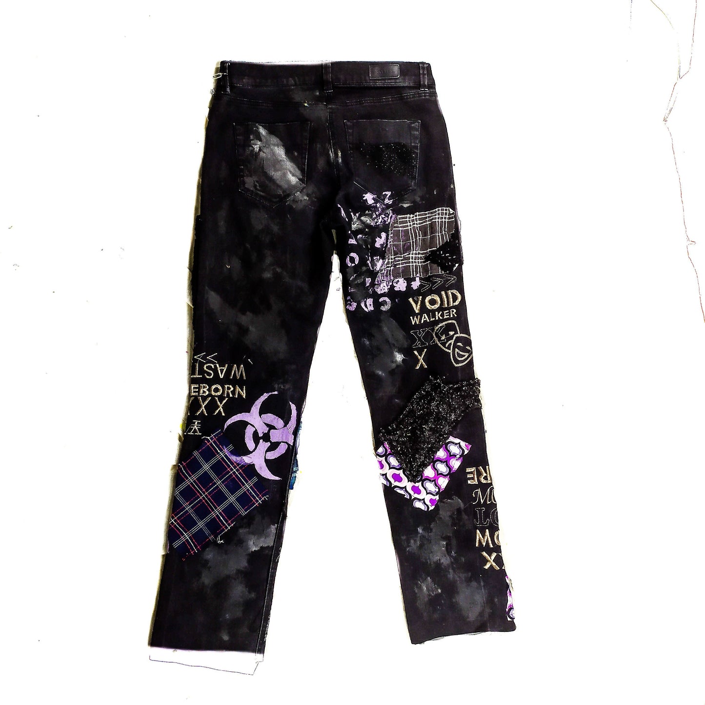 Flat laid black pair with blue and purple patchwork, embroidered words such as void walker and symbols, zippers, studs, ripped patches, chains, abstract painting.